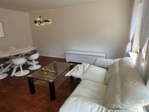 een woonkamer met een witte bank en een tafel bij Ganze Haus für sich 6 Schlafplätze in Buxtehude