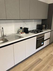 a kitchen with white cabinets and a sink and a stove at Appartamento BELVEDERE in Castiglione Olona