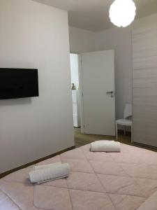 Camera bianca con 2 cuscini su un tappeto di Appartamento BELVEDERE a Castiglione Olona