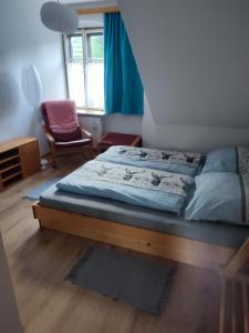 a bedroom with a bed and a chair and a window at Nur 3 Min zu Skilift & 5Min zum See in Mitterbach