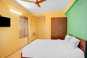 Schlafzimmer mit einem weißen Bett und einem TV in der Unterkunft Flagship Veda Residency in Warangal