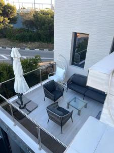 una terraza con sofás, sillas y una mesa. en DeLuxe House Valencia, en Valencia