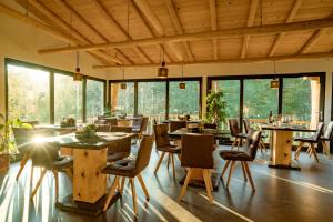 a restaurant with wooden tables and chairs and windows at OM Resort in Gura Teghii
