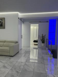sala de estar con sofá blanco y luces azules en DeLuxe House Valencia, en Valencia