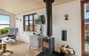 een houtkachel in een woonkamer met een bureau bij 1 Bedroom Stunning Home In Allingåbro in Allingåbro