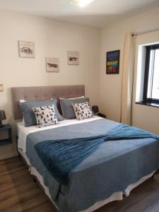 a bedroom with a large bed with blue sheets and pillows at Flat Charmoso Jardim Paulista in Sao Paulo