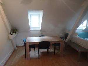 mesa y sillas en una habitación pequeña con cama en Gemütliche Dachwohnung en St. Gallen