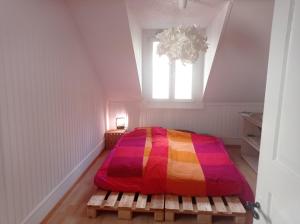 um quarto com uma cama colorida e uma janela em Gemütliche Dachwohnung em St. Gallen