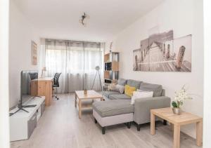 a living room with a couch and a tv at Appartement Zen à Chalon-sur-Saône in Chalon-sur-Saône