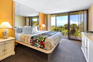 a bedroom with a large bed and a balcony at The Beach Club at St. Augustine in Saint Augustine Beach