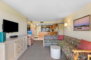 ein Wohnzimmer mit einem Sofa und einem Flachbild-TV in der Unterkunft The Beach Club at St. Augustine in Saint Augustine Beach