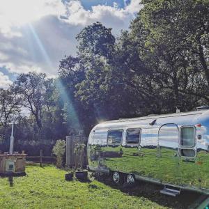 RV zaparkowany na polu z tęczą w tle w obiekcie Airstream, vintage American caravan & Hottub w mieście Ashburton