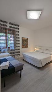 a bedroom with two beds and a window at Splash House in Tirrenia