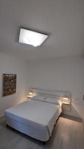 a bedroom with a large bed with a light above it at Splash House in Tirrenia