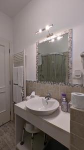 a white bathroom with a sink and a mirror at Splash House in Tirrenia