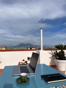 Terrazza Lieti في نابولي: يوجد جهاز كمبيوتر محمول على طاولة في الشرفة