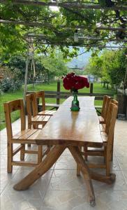 einen Holztisch mit Stühlen und eine Vase mit Blumen darauf in der Unterkunft BUNGALOV in Kemer