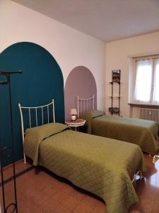 a bedroom with two beds with green sheets at Casa Fresia in Turin