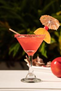 a drink in a martini glass sitting on a table at Hotel Manantial Melgar in Melgar