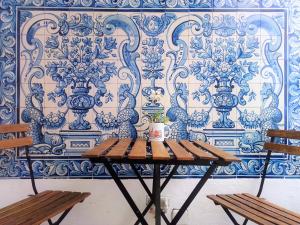 Old Évora Hostel في ايفورا: طاولة مع كرسيين امام جدار ازرق وابيض