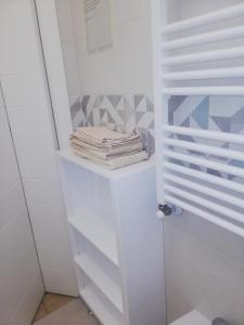Armario blanco con estanterías blancas y toallas en B&B D'Ambrosio, en Milán