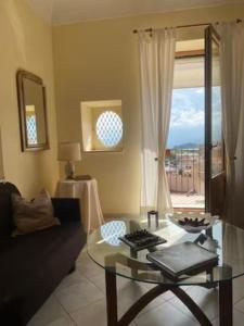 ein Wohnzimmer mit einem Sofa und einem Glastisch in der Unterkunft Appartamento "La Scala" in Taormina