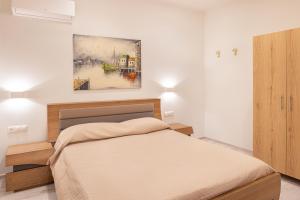 1 dormitorio con 1 cama y una pintura en la pared en Fiera Luxury Apartments., en Kokkari