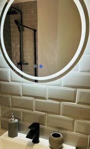 a bathroom with a sink with a large mirror at The Lucky Oak in Belfast