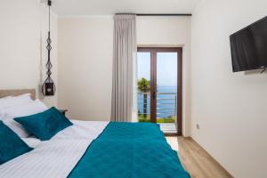 a bedroom with a bed with a view of the ocean at APARTMAN UHAČ in Mošćenička Draga