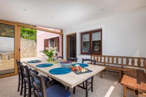 een eetkamer met een houten tafel en stoelen bij APARTMAN UHAČ in Mošćenička Draga