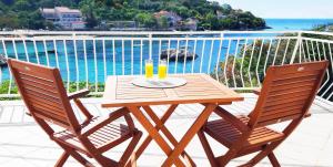 a wooden table with two glasses of orange juice at Villa Ana Apartments in Molunat