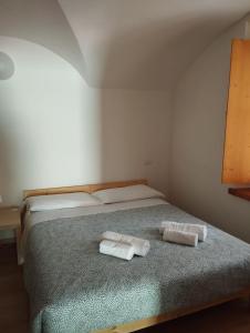 1 dormitorio con 1 cama con 2 toallas en Affittacamere Buon Riposo, en Tarvisio