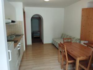 a kitchen and dining room with a table and a couch at Affittacamere Buon Riposo in Tarvisio