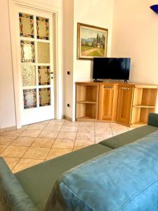 a living room with a couch and a television at Casa Acqua Marina in Castiglione della Pescaia