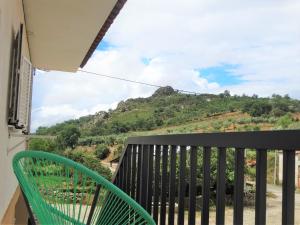 a balcony with a green chair and a mountain at Casa Sardinha 
