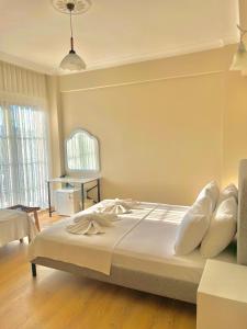 a bedroom with a bed with white sheets and pillows at Cennet Hotel in Fethiye +54 photos