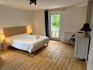 a bedroom with a bed and a window and a desk at Le Chalet - Appartement 5 personnes avec parking in Savignac-les-Ormeaux
