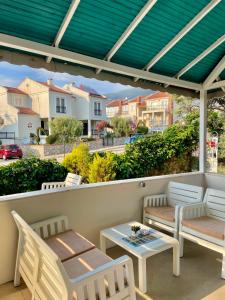 a patio with a table and chairs and a table and a roof at Cennet Hotel in Fethiye