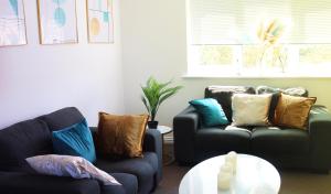a living room with two couches and a table at Flat in London- Modern 2 Bedroom Apartment Harrow near Wembley in Harrow