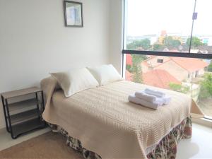 1 dormitorio con 1 cama con 2 toallas en Departamento Inzio, Cómodo y Confortable, en Santa Cruz de la Sierra