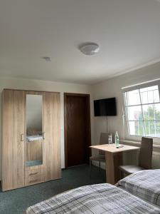 a bedroom with a bed and a desk and a table at Pension Lydia in Leipzig