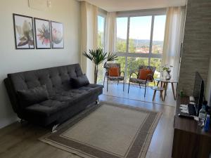 uma sala de estar com um sofá, uma mesa e cadeiras em Aconchego na Serra - Nova Petrópolis em Nova Petrópolis