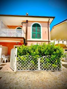 a fence in front of a house with a building at Conero Casa - Marcelli di Numana in Piazzale Tremiti 7 in Marcelli