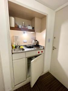 a small kitchen with a sink and a stove at Obelisco 818 in Buenos Aires +7 photos