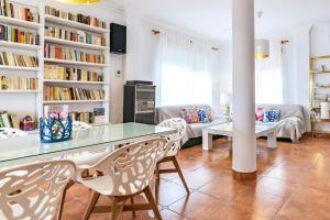 a living room with a table and chairs and bookshelves at Chalet Playa Mazagon in Mazagón