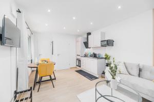 een witte woonkamer met een tafel en een bank bij Lemon Suites Apartment in Stetten in Leinfelden-Echterdingen