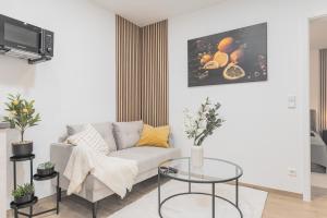 een woonkamer met een bank en een tafel bij Lemon Suites Apartment in Stetten in Leinfelden-Echterdingen