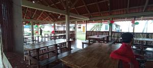 a person standing in a restaurant with benches and tables at San blas Habitacion con comida incluida Icodub in Achoertupo