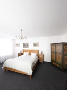 Un dormitorio con una cama grande y una lámpara de araña. en Penzion Jakub en Lanškroun