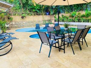 メデジンにあるLuxury Villa In Aguacatala2のパティオ(テーブル、椅子付)、プールが備わります。